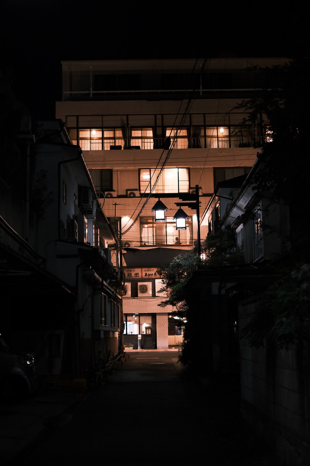 路地の奥に灯る、建物の窓明かり。