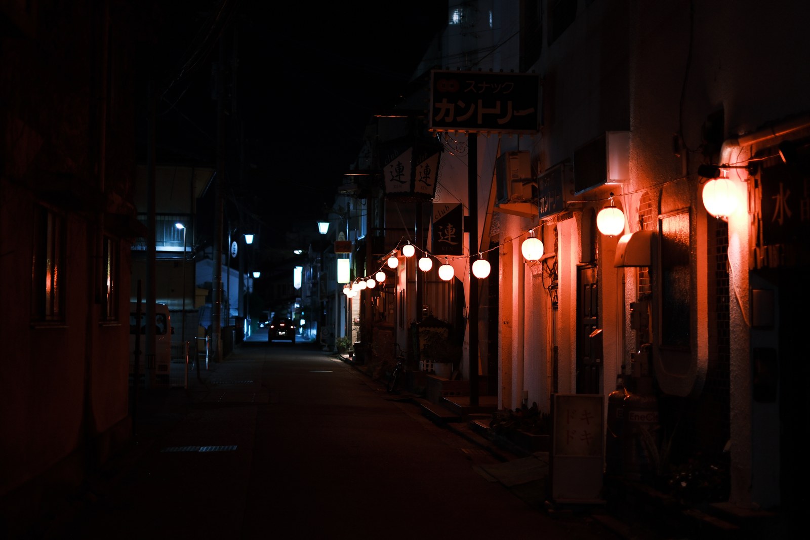 赤い灯りが連なる、夜の通り。