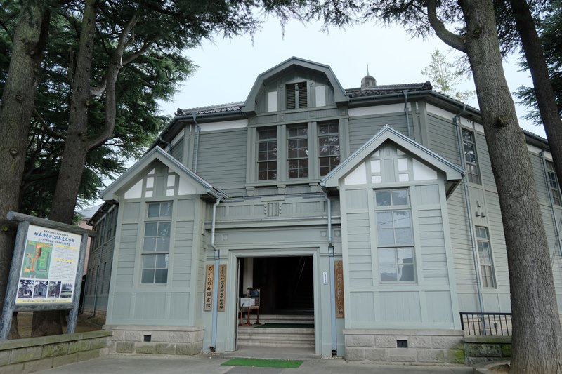木々のあいだの木造建物。